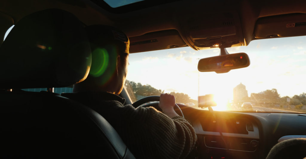 man-driving-into-sunset