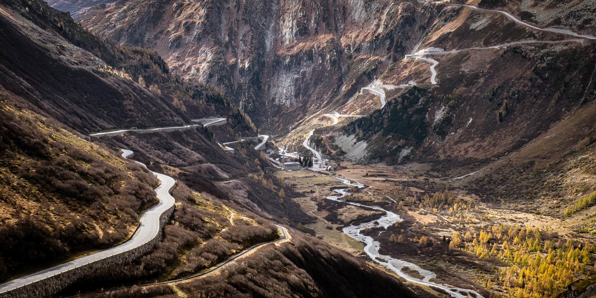 Road through hills shown while driving in switzerland