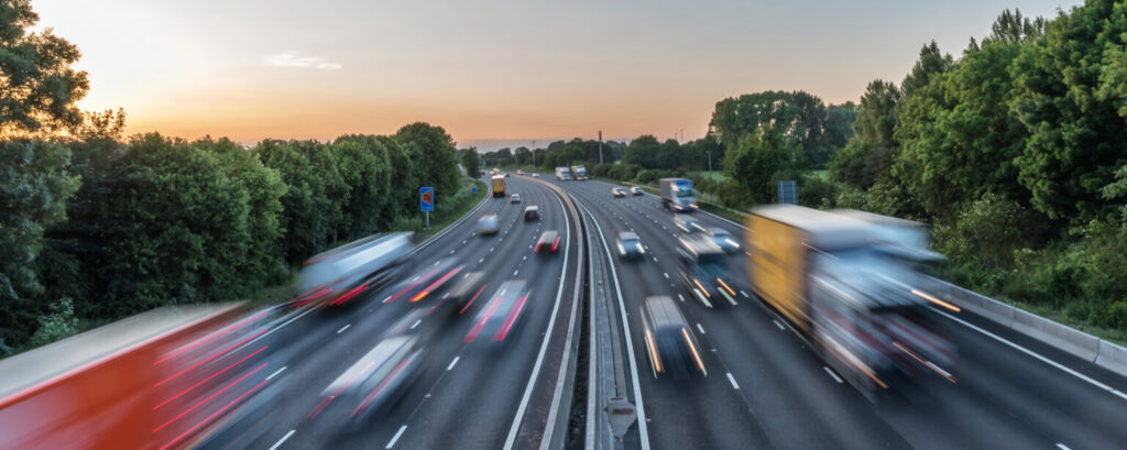 Many cars on a busy motorway at dusk