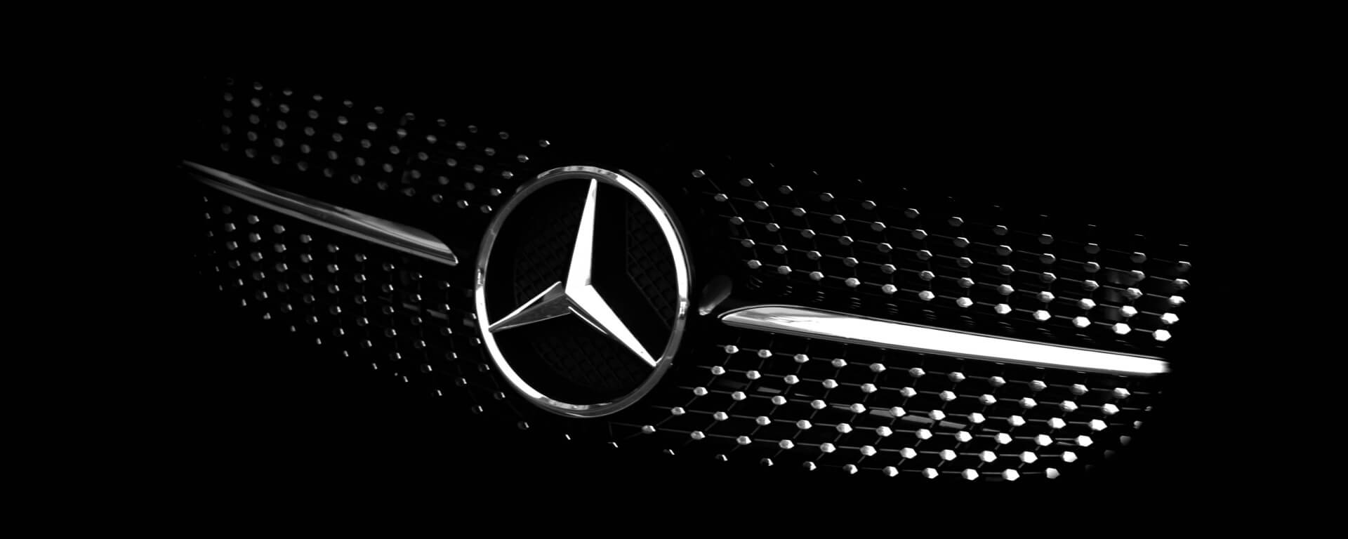 Close up image of the grill of a black Mercedes Benz